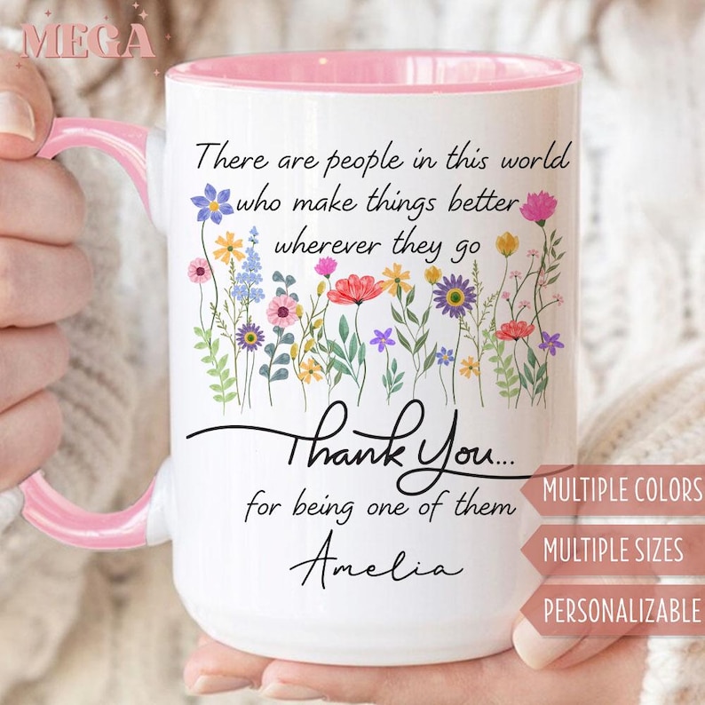 May include: White ceramic mug with a pink interior and handle. The mug features a floral design and the text "There are people in this world who make things better wherever they go. Thank You... for being one of them Amelia."