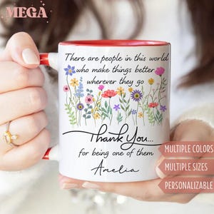 May include: White ceramic mug with a red interior and handle. The mug features a floral design with the text "There are people in this world who make things better wherever they go. Thank You... for being one of them Amelia."
