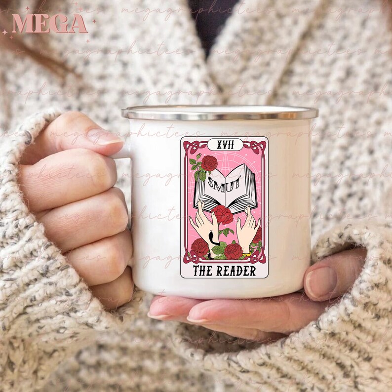 May include: White enamel mug with a pink tarot card design. The card is labeled "XVIII The Reader" and features a book with the word "SMUT" on it.