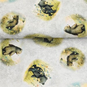 Könnte beinhalten: Ein weißer Stoff mit einem sich wiederholenden Muster aus braunen Bären in einem grasbewachsenen Feld. Die Bären stehen auf ihren Hinterbeinen und haben einen verspielten Gesichtsausdruck.