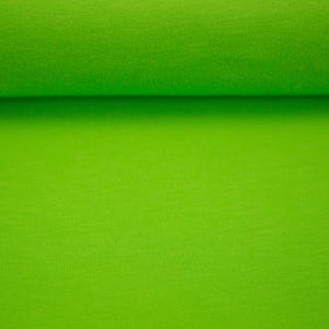 Könnte beinhalten: Nahaufnahme einer Rolle leuchtend grünen Stoffes. Der Stoff hat eine einfarbige, leicht strukturierte Oberfläche. Der Stoff ist aufgerollt, wobei der obere Teil der Rolle sichtbar ist.