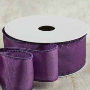 Puede incluir: Un carrete de cinta de sat&eacute;n morado con borde de alambre. La cinta tiene 2,5 pulgadas de ancho y un brillo sutil.