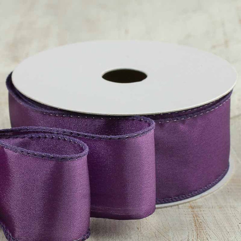 Puede incluir: Un carrete de cinta de sat&eacute;n morado con borde de alambre. La cinta tiene 2,5 pulgadas de ancho y un brillo sutil.