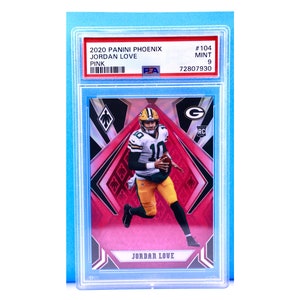 May include: A graded trading card of Jordan Love, a football player for the Green Bay Packers. The card is from the 2020 Panini Phoenix set and is a pink parallel. The card is graded a 9 by PSA and has a black and red design with a diamond pattern.
