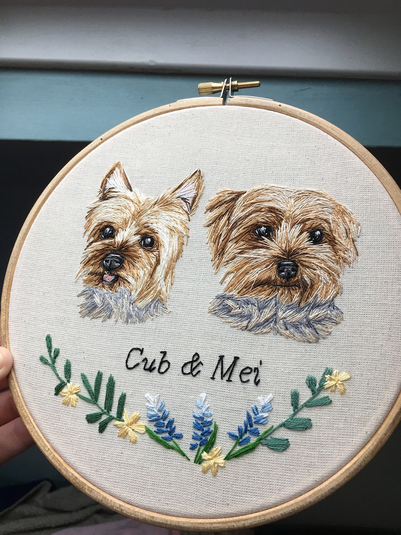 May include: Embroidered portrait of two Yorkshire Terriers, named "Cub & Mei", with a floral design featuring blue and yellow flowers.