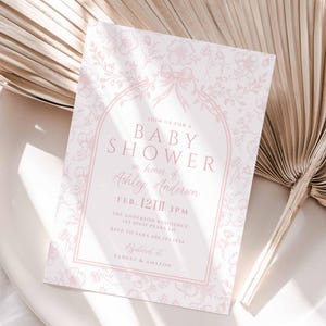 May include: A pink and white baby shower invitation with a floral design. The invitation reads "Join us for a Baby Shower in honour of Ashley Anderson, Feb. 12th 3PM, The Anderson Residence, RSVP to Sarah at 555-1212, Gifts to Target & Amazon".
