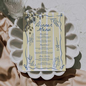 May include: A dinner menu card with a yellow and white striped background, adorned with blue illustrations and text. The menu includes sections for appetizers and main courses, with decorative floral and ribbon elements.