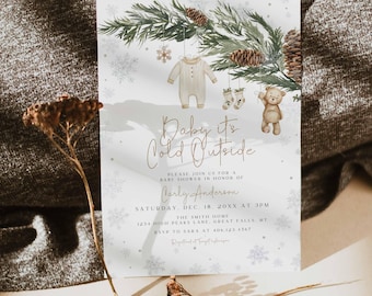 Könnte beinhalten: Babyparty-Einladung mit dem Text "Baby it's Cold Outside". Die Einladung zeigt eine Aquarellillustration eines Baby-Stramplers, Socken und eines Teddybären, die an Kiefernzweigen hängen. Die Einladung enthält den Namen Carly Anderson und die Veranstaltungsdetails.