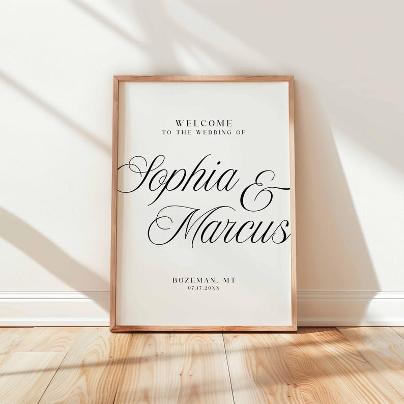 Pu&ograve; includere: Un cartello di benvenuto per matrimoni incorniciato con i nomi "Sophia & Marcus" in elegante corsivo. Il cartello include la localit&agrave;, Bozeman, MT, e la data, 07.17.20XX. La cornice &egrave; marrone chiaro e lo sfondo &egrave; bianco sporco.