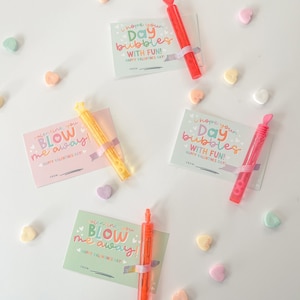 May include: Three Valentine's Day cards with bubble wands attached. The cards are pink, green, and light blue with colorful text that says "Valentine, you blow me away!" and "I hope your day bubbles with fun!"