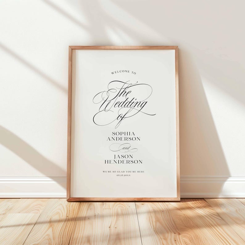 May include: A rectangular wedding welcome sign in a light wood frame featuring black text on a white background. The text reads: Welcome to The Wedding of Sophia Anderson and Jason Henderson. We're so glad you're here. 05.23.20XX.