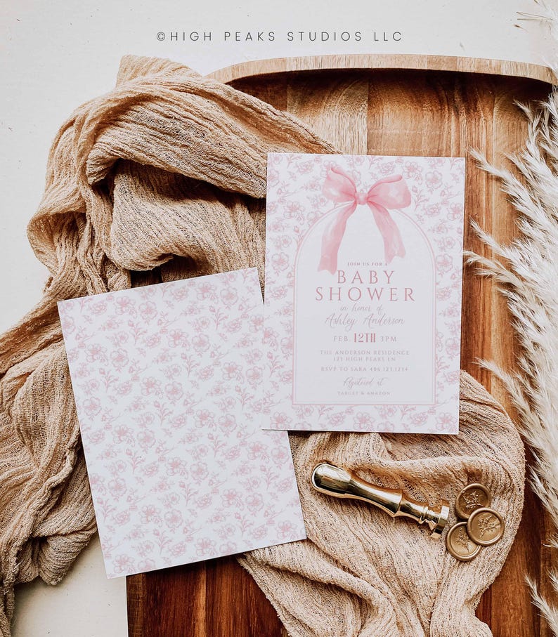 May include: A pink and white baby shower invitation with a pink bow and the text "Baby Shower for Ashley Anderson Feb 12th 2 PM The Anderson Residence RSVP to Sarah 555-555-5555 High Peaks Studios LLC"