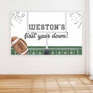 Op de afbeelding: Een wit en groen voetbalveld met een voetbaldoel en een bruine voetbal. De tekst "WESTON'S first year down!" staat op de goalpost.