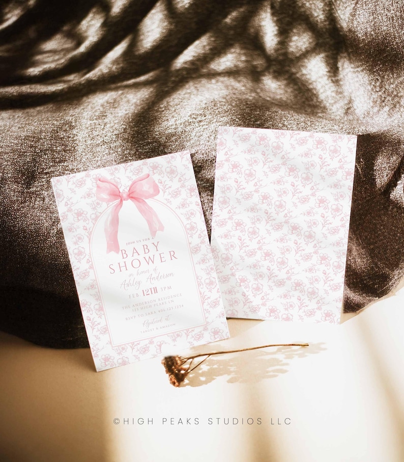 May include: A pink baby shower invitation with a pink bow and a floral pattern. The invitation reads "Join us to celebrate a Baby Shower in honor of Ashley Anderson, 12th 5pm".