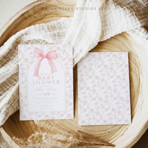 May include: A pink and white baby shower invitation with a pink bow and the text "Join us for a Baby Shower in honor of Ashley Anderson, Feb. 12th 3 PM, The Anderson Residence, 123 Main Street, Anytown, CA 12345, RSVP to Sarah at 123-456-7890".