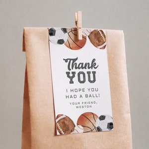 May include: A brown paper bag with a thank you tag attached. The tag has a watercolor design of sports balls and the text "Thank You I hope you had a ball! Your friend, Weston".