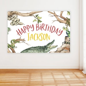Puede incluir: Un fondo blanco con un cocodrilo verde, serpientes y lagartos. El texto "Happy Birthday Jackson" está escrito en letras rojas y amarillas.