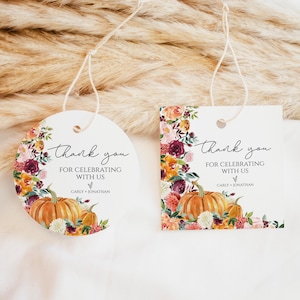Può includere: Due etichette regalo con spago, una rotonda e una quadrata. Entrambe presentano un design ad acquerello di zucche e fiori arancioni, bordeaux e gialli. Il testo recita "Thank you for celebrating with us" e i nomi "Carly + Jonathan".