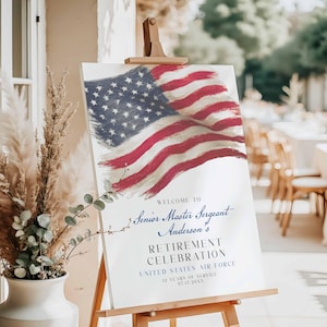 May include: A white sign on a wooden easel features an American flag design in red, white, and blue. The sign reads "WELCOME TO Senior Master Sergeant Anderson's RETIREMENT CELEBRATION UNITED STATES AIR FORCE 12 YEARS OF SERVICE 07.17.20XX."