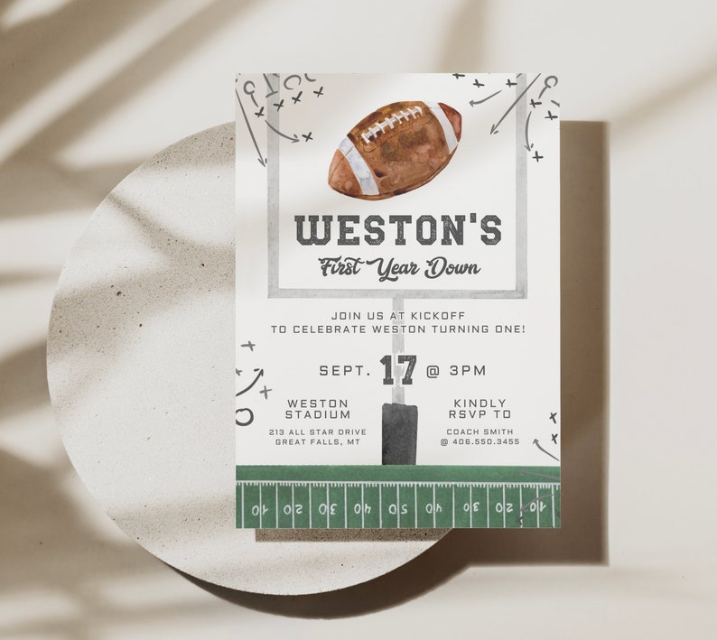 May include: A green and white football-themed invitation for a first birthday party. The invitation features a football, a football field, and the text "WESTON'S First Year Down". The invitation also includes the date, time, and location of the party.