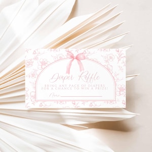 May include: A pink and white diaper raffle ticket with a floral design and a pink bow. The text reads "Diaper Raffle" and "Bring any pack of diapers for a chance to win a prize!" with a blank line for a name.
