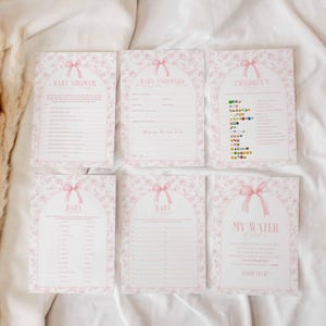 May include: A set of six printable baby shower game cards with pink floral designs and text. The cards include games like "Baby Shower Bingo", "Baby Advice", "Guess the Baby Food", "Who Knows Mommy Best", "My Water Broke", and "Children's Book Guessing Game".