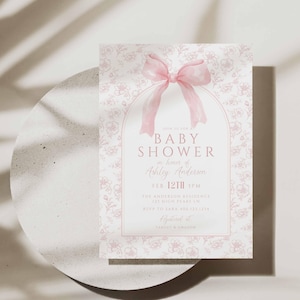 May include: A pink and white baby shower invitation with a floral pattern and a pink bow. The text reads "Join us for a Baby Shower in honor of Ashley Anderson, Feb. 12th 3PM, The Anderson Residence, 121 High Pears Ln, RSVP to Sara 408-123-1234, Registered at Target & Amazon."