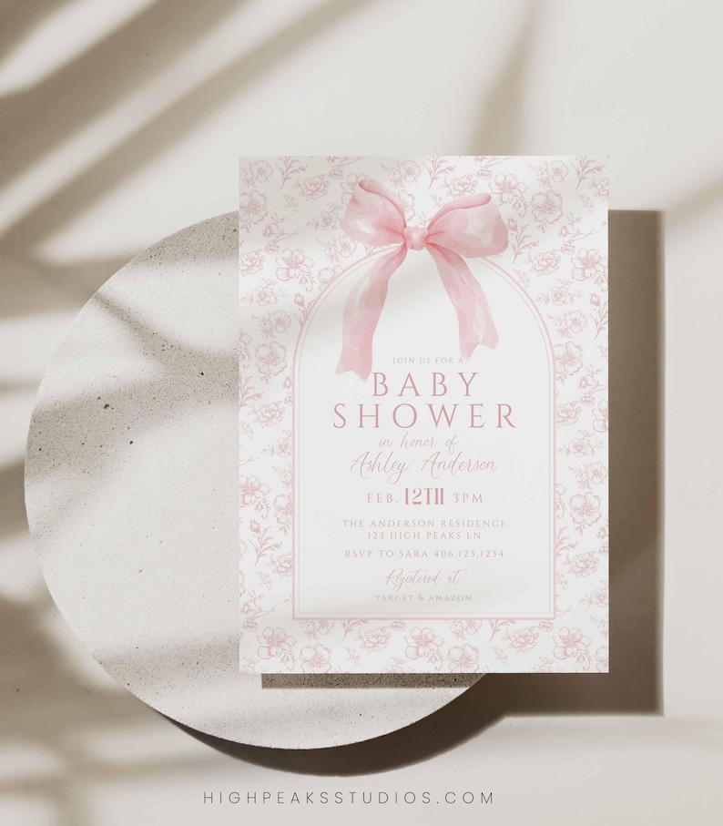 May include: A pink and white baby shower invitation with a floral pattern and a pink bow. The text reads "Join us for a Baby Shower in honor of Ashley Anderson, Feb. 12th 3PM, The Anderson Residence, 121 High Pears Ln, RSVP to Sara 408-123-1234, Registered at Target & Amazon."