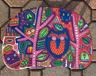 May include: A colorful, hand-painted wooden owl with a whimsical design. The owl is surrounded by leaves, branches, and other geometric patterns in shades of pink, purple, green, blue, and red.