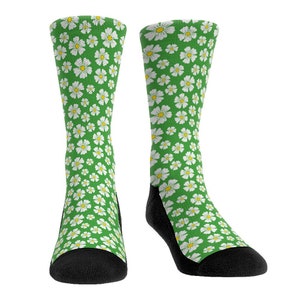 May include: A pair of green socks with a white daisy pattern. The socks have black toes and heels.