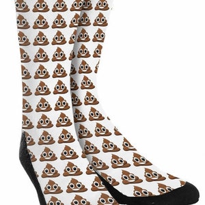 May include: A pair of white socks with a brown poop emoji pattern. The socks have black elastic at the top and black toes.