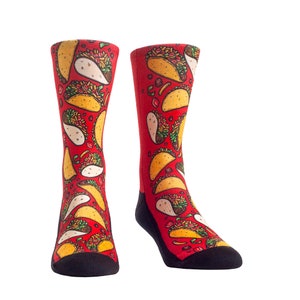 May include: A pair of red socks with a repeating pattern of yellow and white tacos. The socks have black heels and toes. The tacos are filled with various ingredients.