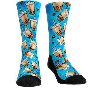 May include: A pair of blue socks with a pattern of brown boba tea cups with black tapioca pearls and white straws. The socks are black at the toe and heel.