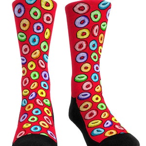 May include: A pair of red socks patterned with colourful, cereal-like circles. The socks have black heels and toes. The circles are in various colours, including yellow, blue, green, and purple.