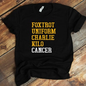 May include: Black t-shirt with the words "FOXTROT UNIFORM CHARLIE KILO CANCER" in yellow letters.