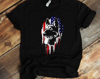 May include: Black t-shirt featuring a white silhouette of a German Shepherd dog's head against an American flag.