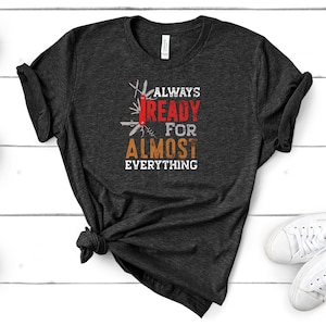 May include: A dark gray t-shirt with a graphic of a multi-tool and the text "ALWAYS READY FOR ALMOST EVERYTHING".