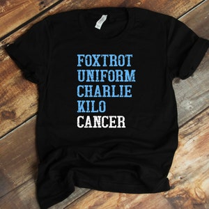 May include: Black t-shirt with the words "FOXTROT UNIFORM CHARLIE KILO CANCER" printed in blue and white.