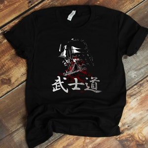 May include: Black t-shirt with a white graphic of a samurai warrior wearing a helmet and the Japanese text "武士道" (Bushido) meaning "The Way of the Warrior".