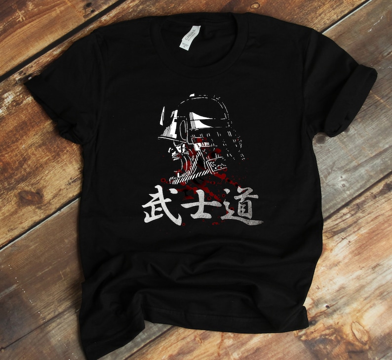 May include: Black t-shirt with a white graphic of a samurai warrior wearing a helmet and the Japanese text "武士道" (Bushido) meaning "The Way of the Warrior".