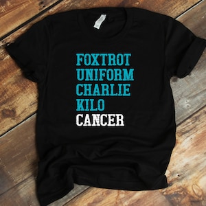 May include: Black t-shirt with the words "FOXTROT UNIFORM CHARLIE KILO CANCER" in turquoise blue lettering.
