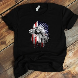May include: Black t-shirt with a graphic of a dog's head in front of an American flag.