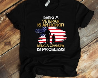 May include: Black t-shirt with a gold graphic design featuring an American flag, a silhouette of a man and a child, and the text "Being a Veteran is an Honour, Being a Grandpa is Priceless."
