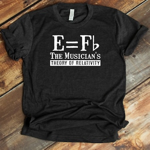 May include: A dark gray t-shirt with a white graphic that reads "E=F# The Musician's Theory of Relativity".