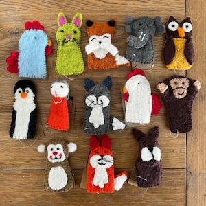 May include: A set of 14 felt finger puppets featuring various animals, including a fox, owl, penguin, cat, chicken, monkey, and elephant. The puppets are brightly coloured and have friendly faces.