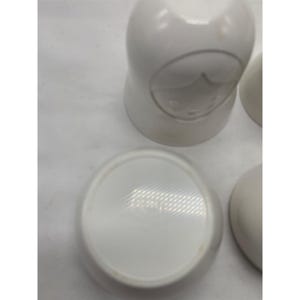 Puede incluir: Un conjunto de mu&ntilde;ecas rusas de cer&aacute;mica blanca con superficies lisas y redondeadas. Una mu&ntilde;eca se muestra desde arriba, revelando una base circular con un logotipo tenue en relieve. Las otras mu&ntilde;ecas son parcialmente visibles con contornos faciales.