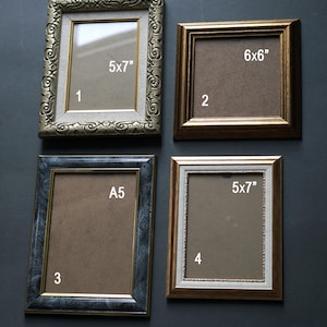 May include: Four picture frames in different sizes and styles. The frames are numbered 1 through 4. Frame 1 is gold with an ornate design and measures 5x7 inches. Frame 2 is gold with a simple design and measures 6x6 inches. Frame 3 is blue and grey with a marbled design and measures A5. Frame 4 is gold with a simple design and measures 5x7 inches.