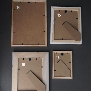 Op de afbeelding: Vier houten fotolijsten met een bruine kartonnen achterkant. De lijsten zijn genummerd 14, 15, 16 en 17.