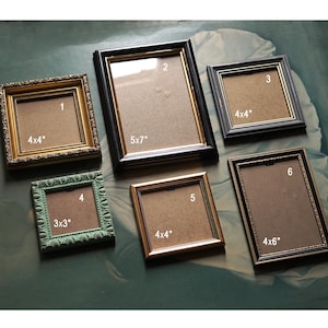 May include: Six picture frames in various sizes and colours. The frames are made of wood and have a variety of decorative details. The frames are labelled with numbers 1 through 6 and their dimensions in inches.