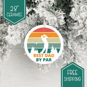 Peut inclure: Une décoration en céramique de 7,1 cm avec un design de coucher de soleil rétro. Une silhouette de golfeur est au centre de la décoration. Le texte "Best Dad By Par" est imprimé sur la décoration.
